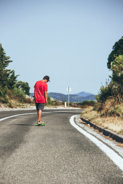 Longboarder riding down a coastal road
