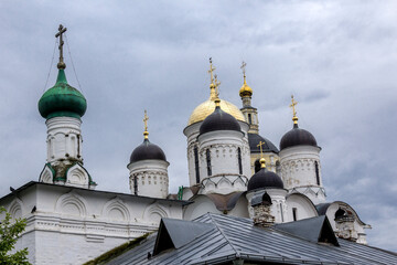 Fototapeta na wymiar There are many different domes over the churches. View from the garden. Panfutyevsky Monastery in Borovsk, Russia.