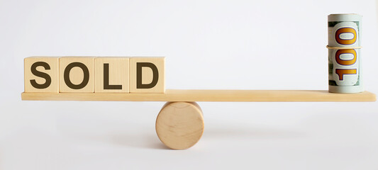 Seesaw Showing Balance Between money And word SOLD