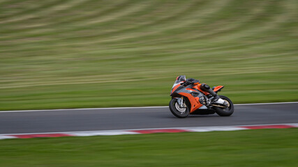 Fototapeta premium A panning shot of a racing bike cornering as it circuits a track.