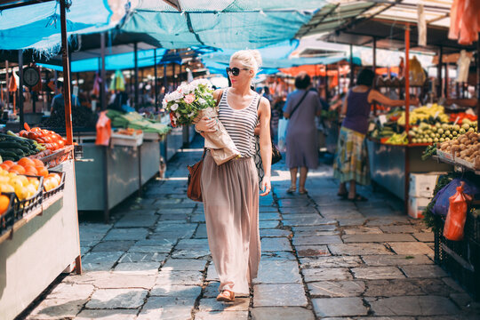 Smiling Woman Carrying Flowers
