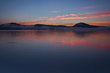Fototapeta na wymiar 夜明けの空を映す朝の湖。屈斜路湖、北海道。
