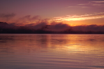 Fototapeta na wymiar 雲の漂う早朝の湖。屈斜路湖、北海道。