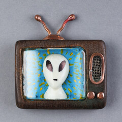 An alien on the screen of an old vintage TV. Handmade wood TV. 1980s, 1970s, 1960s.