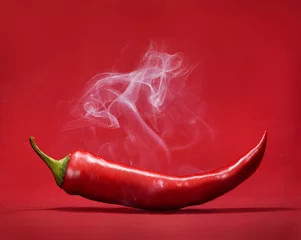 Foto op Plexiglas Hete pepers Red hot chili peper op rode achtergrond met rook. Stilleven met stoom Mexicaans paprikakruid.