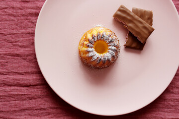 Curd muffin and pieces of chocolate on a plate.