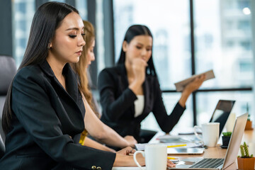 Happy Asian businesswoman office worker using laptop computer and digital tablet for success meeting business project. Confidence working woman colleague teamwork brainstorming ideas in modern office.