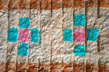 The wall background pattern has orange alternating with blue and pink.