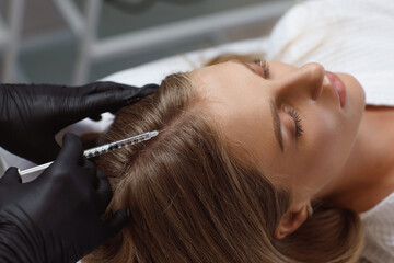 Doctor cosmetologist making mesotherapy injections in woman's head