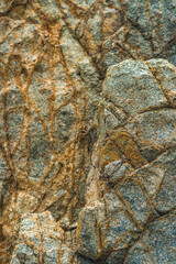 Close up view bright vivid orange brown yellow stone rock shabby cliff cracks texture mountains. Concept of geology, beauty power in nature. Natural summer composition landmark background design