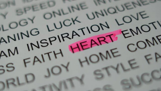 The Marker Highlights the Text Sign"HEART". A Hand on a Piece of Paper Emphasizes the Word "HEART" with a Pink Marker, Close-up. 