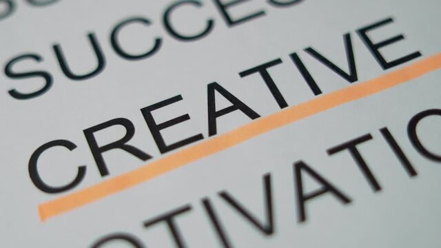 Underline a Large printed word on a piece of paper "CREATIVE", Macro. The Concept Of Creativity.