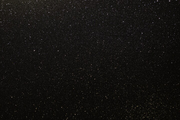 Black texture with micro-relief and glitter similar to the night sky with stars