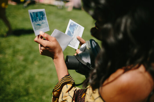 A young woman examining recent polaroids she took