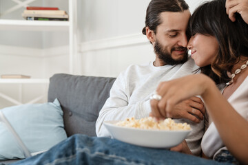 Obraz na płótnie Canvas Photo of romantic happy beautiful couple hugging and eating popcorn