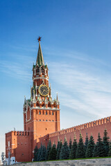 Fototapeta na wymiar The Kremlin's Spasskaya Tower on Red Square against the backdrop of a bright blue sky on a sunny day. Vertical.