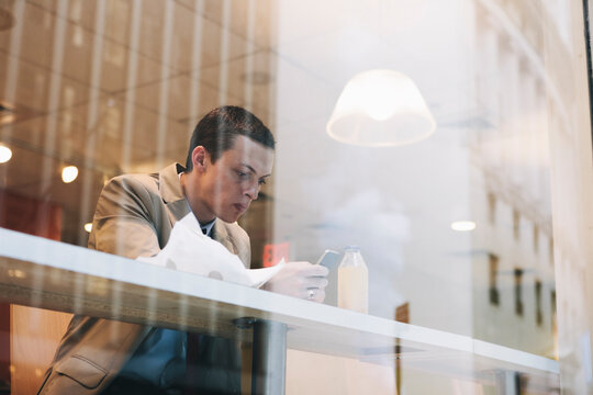 Young Professional Eating Quick Lunch in a Deli in New York's Wall Street Business District