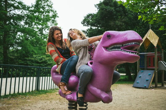 Young and free friends having fun on a T Rex in the park