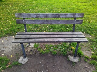 old and gray wooden bench in the park in the autumn season