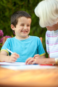 senior woman helping a young boy with his school work