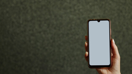 A woman's hand holds a phone.