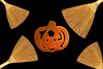 Brooms and pumpkin shape isolated on black background. Background to Halloween