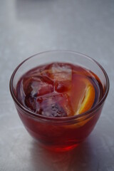 Negroni cocktail with ice cubes and garnished with a slice of orange