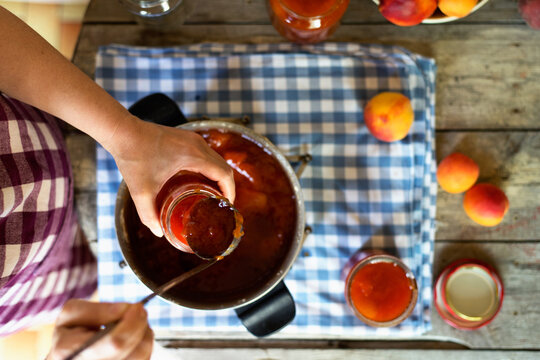 Woman preparing peach and apricot preserve