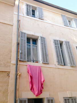 Pink sheet hands out of window