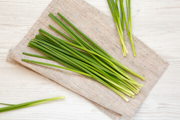 Raw Green Onions on a white wooden background, top view. Flat lay, overhead, from above.