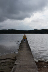 Fototapeta premium Holzsteg Wasser Gelbe Regejacke