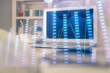 Financial graph colorful drawing and table with computer on background. Double exposure. Concept of international markets.