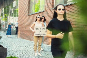 Follow me on Instagram. Dude with sign - woman stands protesting things that annoy her. Solo demonstration right to talk free on the street with sign. Opinion heard by public. Social life, SMM.