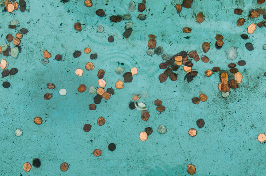 coins scattered underwater water in a fountain