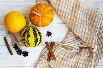Small pumpkins on white wooden background. Autmn composition, thanksgiving day concept. Halloween flatlay. Cosy autmn photo.