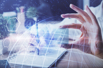 Double exposure of hands making notes with world map hologram and data theme icons. Concept of global computer data.