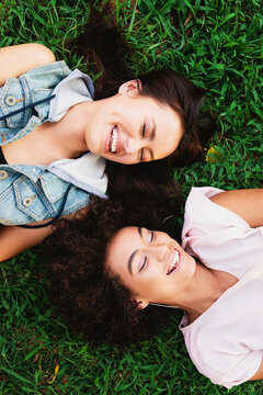 Two laughing girls laying on the grass