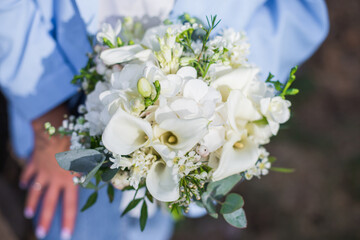 Wedding bouquet in bride hands. Roses, eustoma, eucalyptus in elegant bouquet. Summer and autumn flowers.