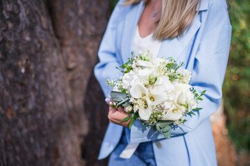 Wedding bouquet in bride hands. Roses, eustoma, eucalyptus in elegant bouquet. Summer and autumn flowers.