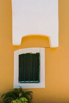 Unusual orange building. Orange walls and a green barred window
