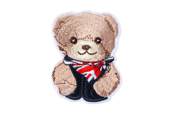 Teddy bear in blue jacket with UK neckerchief patch, isolated on white