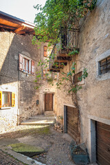 Fototapeta na wymiar Detail of the old houses facades and alleys in Bagolino, a small town in the Lombardy Region (province of Brescia), famous for its Bagoss cheese made with goat's milk. Color image.