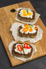 Different kinds of colorful sandwiches on cutting board.