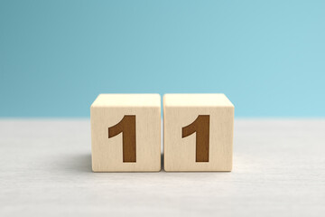 Wooden toy blocks forming the number 11. - obrazy, fototapety, plakaty