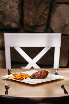 Grilled strip steak with bearnaise sauce and potato wedges
