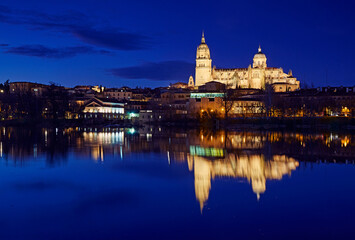 Fototapeta na wymiar Salamanca Cathedral overlooking the River Tormes illuminated at twilight