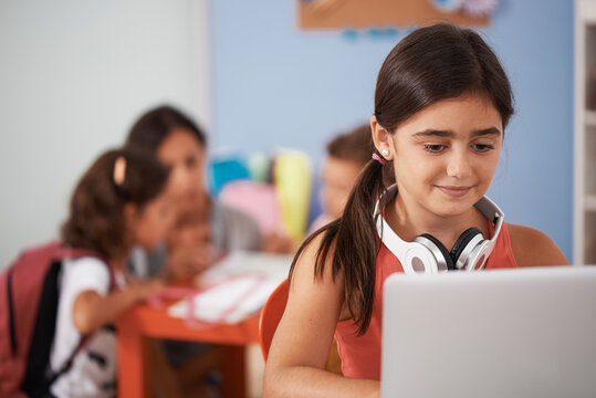 Brunette girl using laptop for doing some homework. Family in background