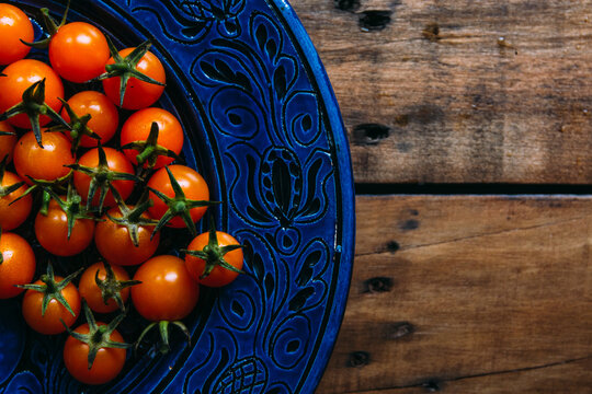 Yellow Cherry Tomatoes in a Blue Ceramic Plate From Above - Powered by Adobe