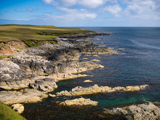 Dramatic coastal scenery showing inclined and eroded rock strata around the Ness of Queyon, near Otters Wick on the island of Yell in Shetland, Scotland, UK - metamorphic bedrock