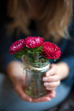 woman holding a jam jar with flowers